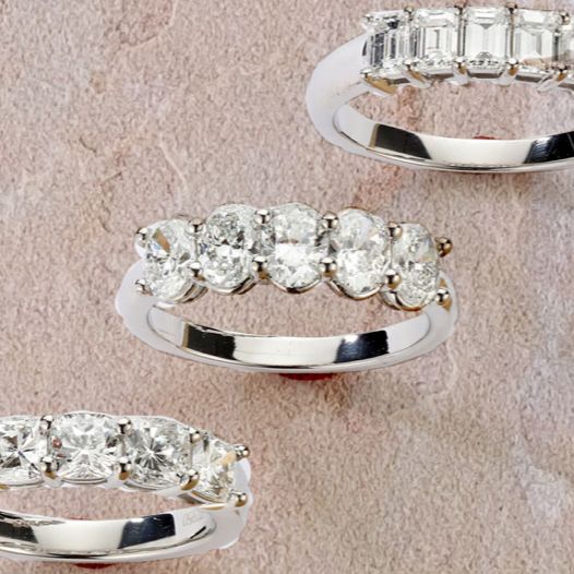 Three five stone diamond rings in different diamond shapes all in white gold.