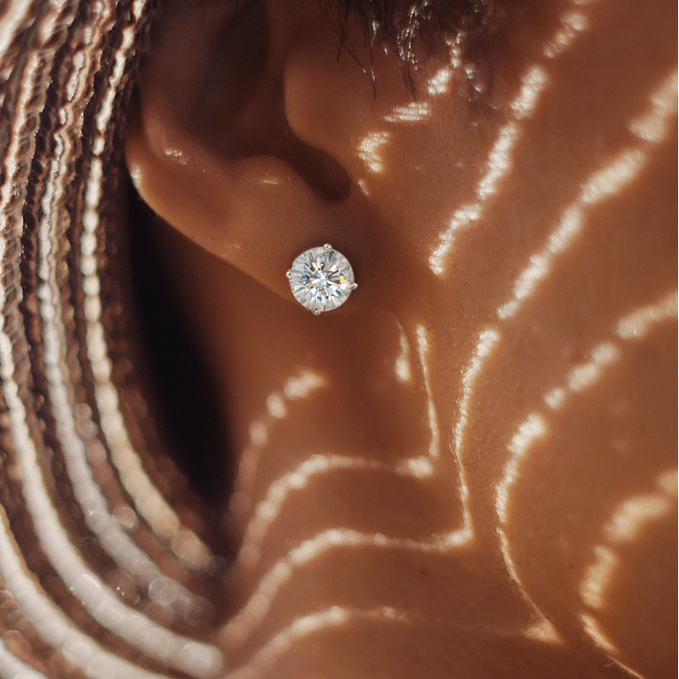 a woman wearing diamond stud earrings